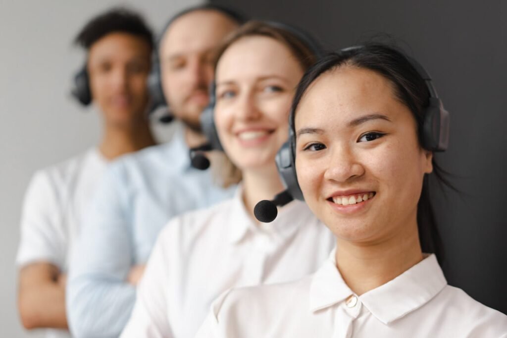 Smiling diverse team of customer support representatives wearing headsets, ready to assist.